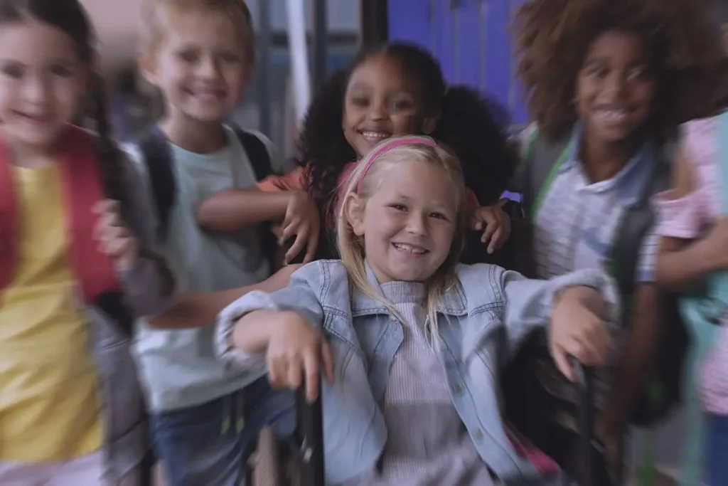 bambina su sedia a rotelle con molti amici