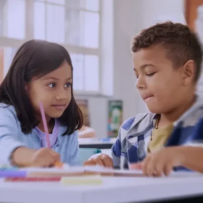 bambina e bambino in ambiente scolastico studiano insieme