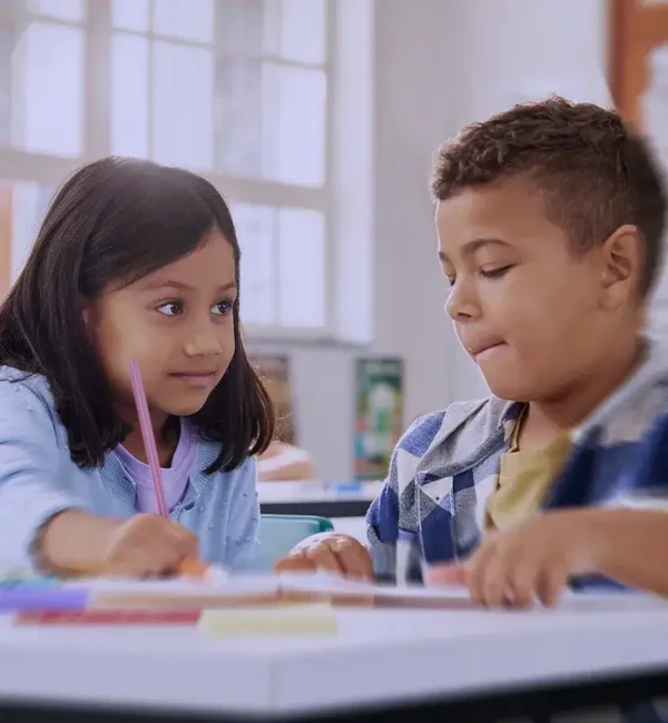 bambina e bambino in ambiente scolastico studiano insieme