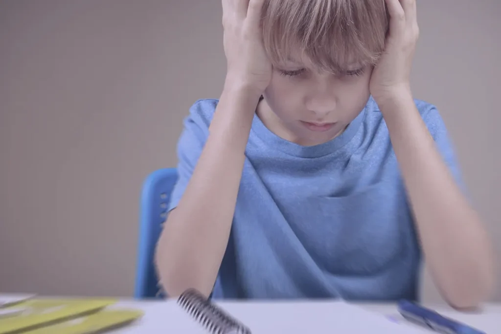 bambino scuola primaria che garda preoccupato un foglio bianco