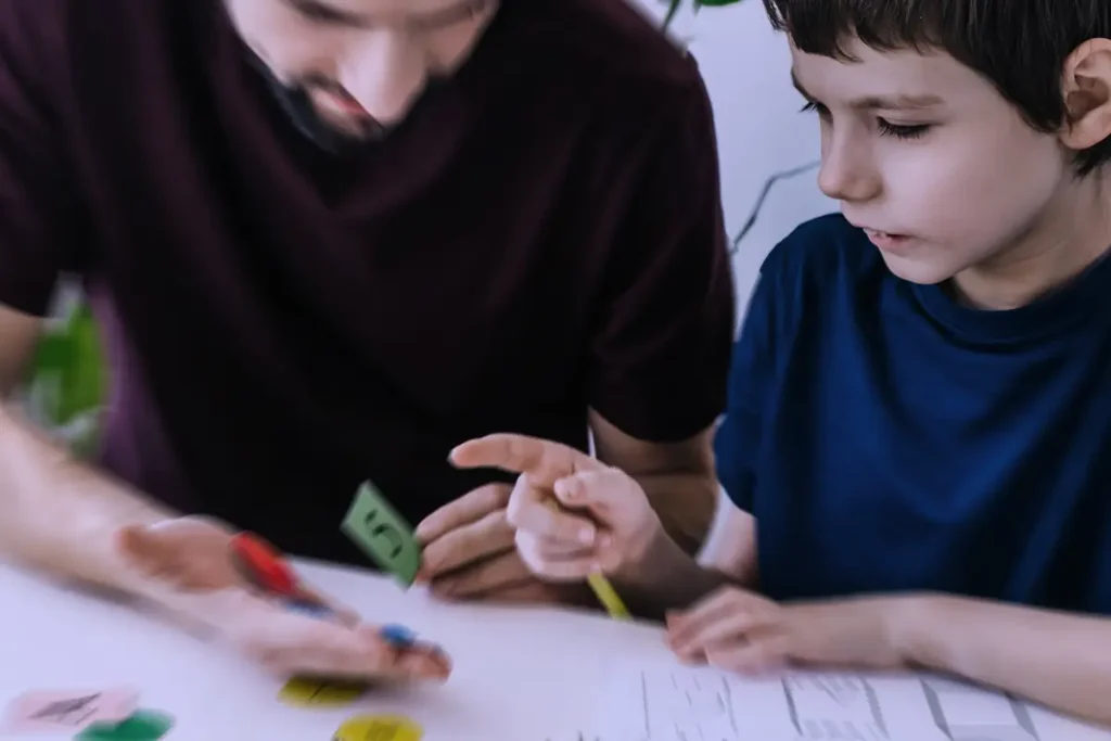 Adulto supporta un bambino nello svolgimento di un compito con materiali e indicazioni passo passo