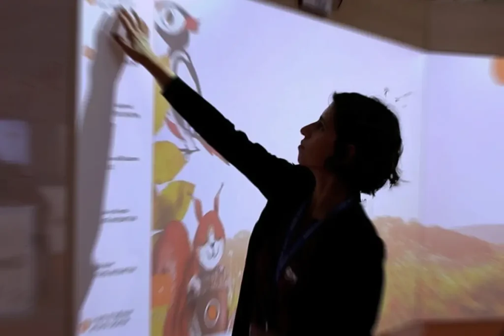 Docente interagisce con una proiezione in aula Miri durante un’attività di narrazione immersiva