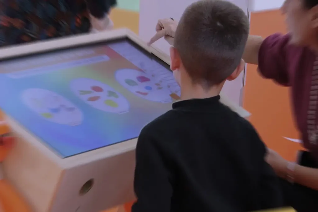 Bambino utilizza il banco interattivo Pinguin per un esercizio su orologio e concetti di tempo
