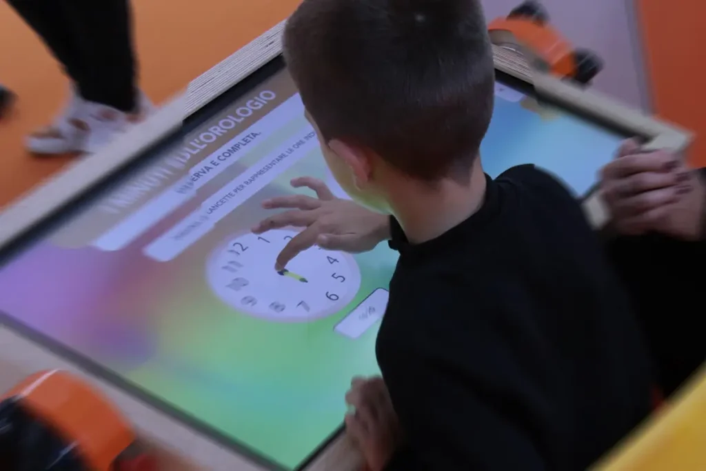 Bambino alla scuola dell’infanzia interagisce con il banco Pinguin in un’attività di classificazione e associazione